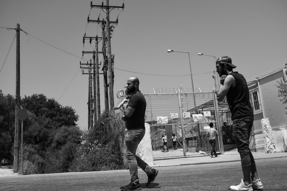 Men with a young child outside the refugee camp Moria, Lesbos, Greece