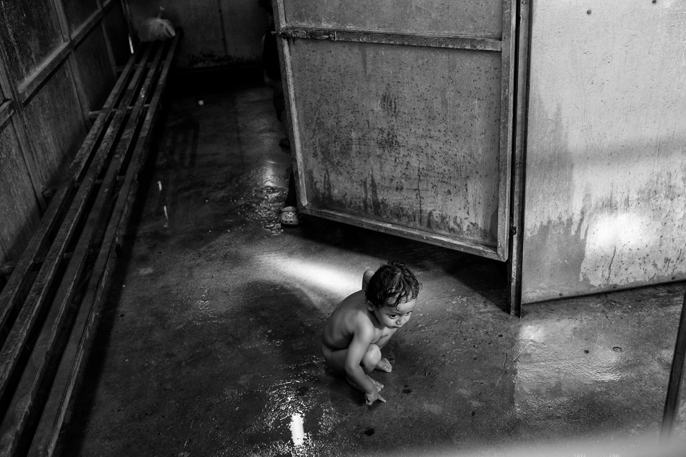 A Syrian boy at a shower inside the refugee camp Moria, Lesbos, Greece.