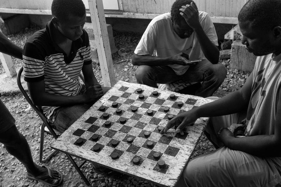 Africans are playing checkers inside the refugee camp Moria, Lesbos, Greece